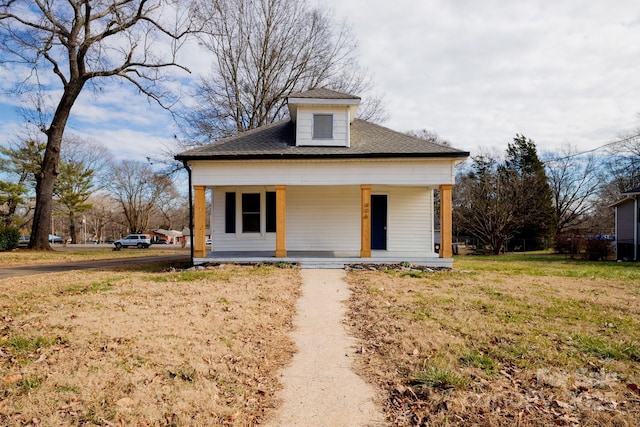 bungalow-style home with covered porch and a front lawn