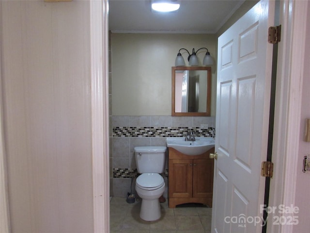 bathroom featuring vanity, tile walls, tile patterned floors, and toilet