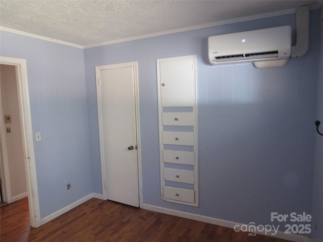 unfurnished bedroom with dark hardwood / wood-style flooring, a wall mounted air conditioner, crown molding, and a textured ceiling