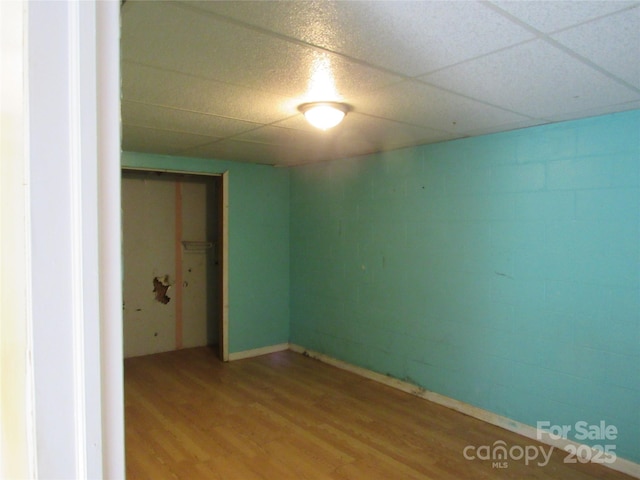 unfurnished room with hardwood / wood-style flooring and a drop ceiling