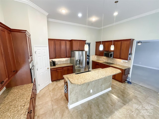 kitchen with light stone countertops, a kitchen island, stainless steel appliances, hanging light fixtures, and ornamental molding