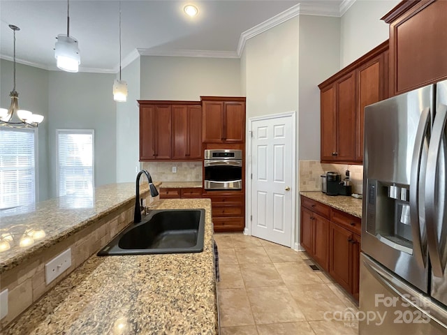 kitchen featuring stainless steel appliances, pendant lighting, tasteful backsplash, and sink