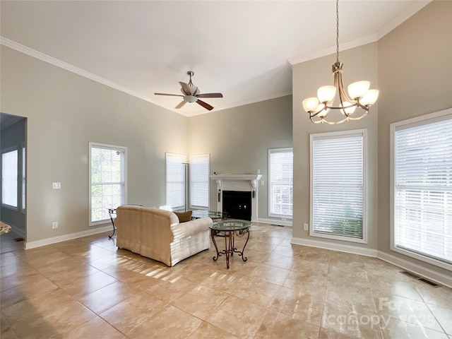 living room featuring crown molding, ceiling fan with notable chandelier, and a towering ceiling