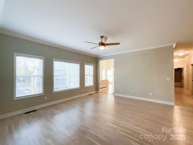 empty room with ceiling fan, ornamental molding, and light hardwood / wood-style floors