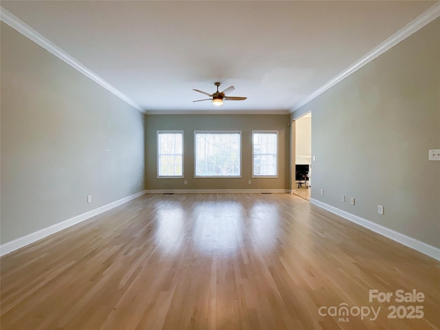 unfurnished living room with ceiling fan, ornamental molding, and light wood-type flooring