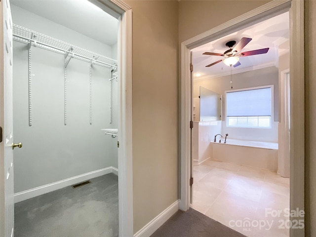 bathroom featuring a tub, crown molding, and ceiling fan