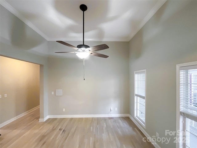 empty room featuring ceiling fan, ornamental molding, light hardwood / wood-style floors, and a high ceiling