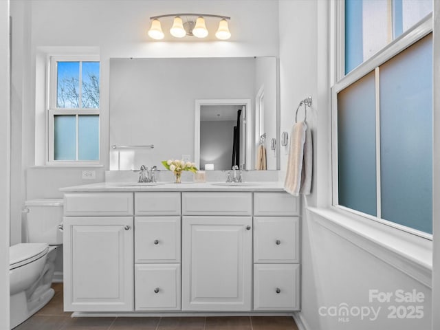 bathroom with toilet, tile patterned floors, and vanity