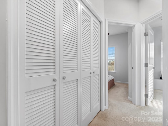 hall featuring light colored carpet