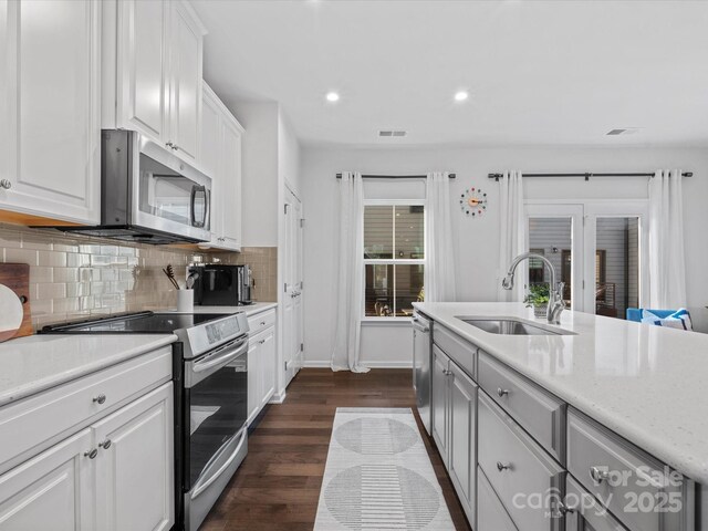 kitchen with white cabinetry, appliances with stainless steel finishes, backsplash, dark wood-type flooring, and sink