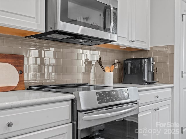 kitchen featuring tasteful backsplash, white cabinets, and stainless steel appliances