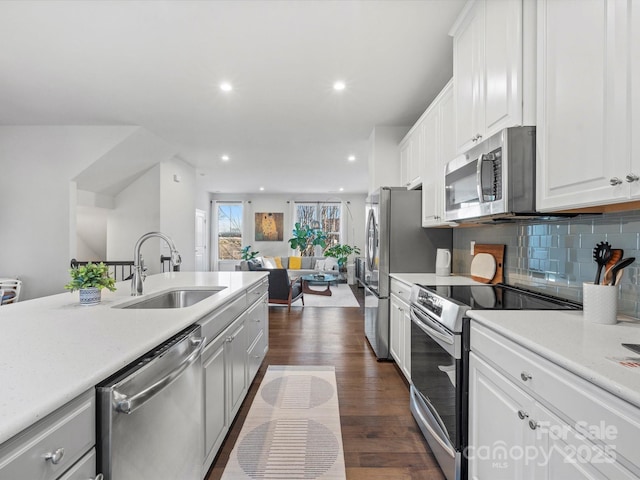 kitchen featuring white cabinetry, dark hardwood / wood-style flooring, stainless steel appliances, tasteful backsplash, and sink