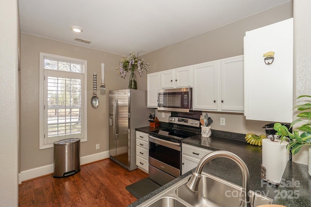 kitchen featuring dark wood-type flooring, white cabinets, appliances with stainless steel finishes, and sink