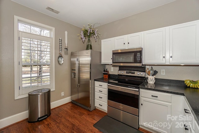 kitchen featuring appliances with stainless steel finishes, white cabinetry, and dark hardwood / wood-style floors