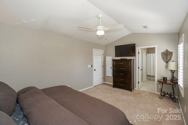 bedroom with ceiling fan, light colored carpet, connected bathroom, and lofted ceiling