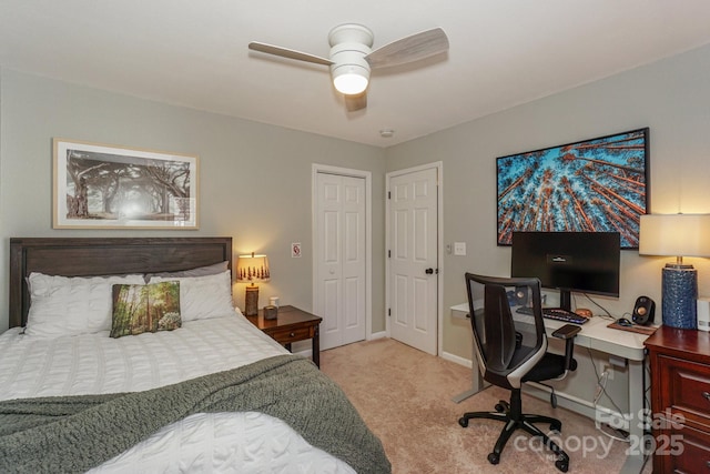 bedroom with ceiling fan, light colored carpet, and a closet