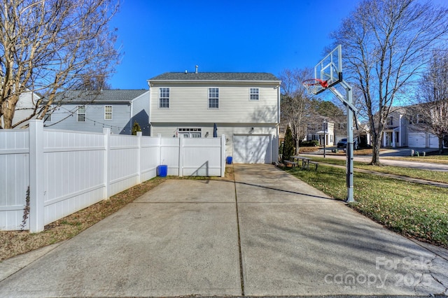 rear view of property featuring a lawn and a garage