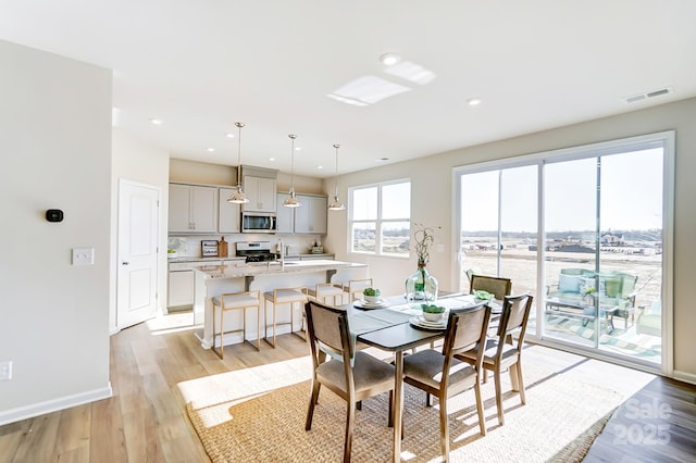 dining room with sink and light hardwood / wood-style flooring