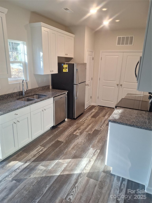 kitchen with stainless steel appliances, white cabinets, and sink