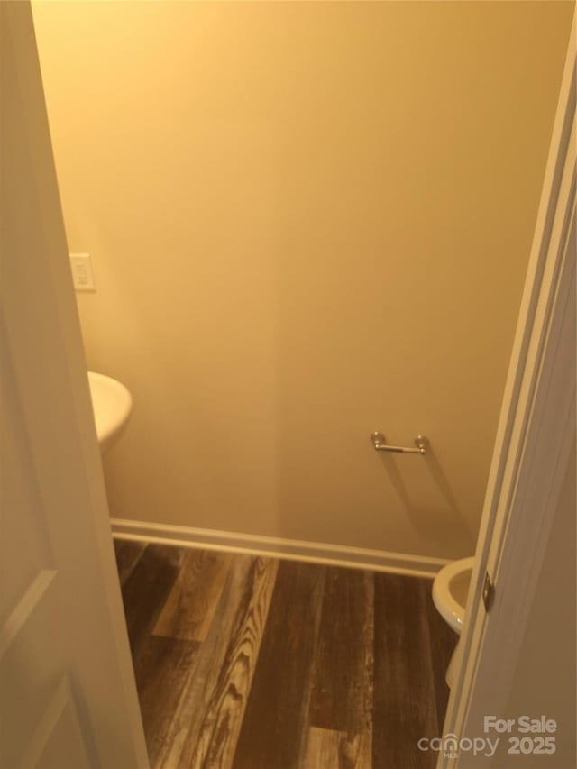 bathroom featuring toilet and wood-type flooring