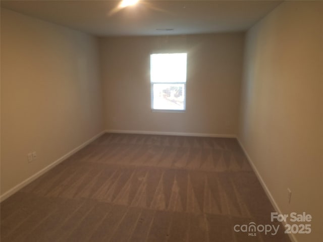 unfurnished room featuring dark carpet