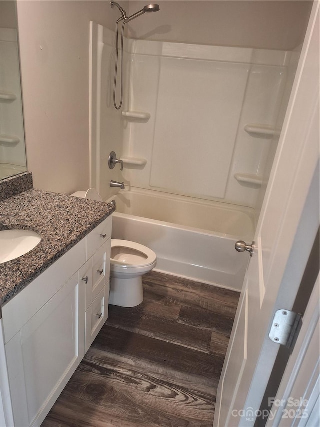 full bathroom with shower / bathing tub combination, vanity, wood-type flooring, and toilet