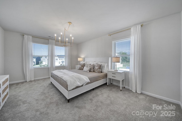 carpeted bedroom featuring an inviting chandelier