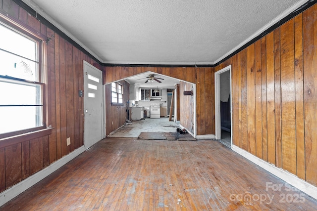 unfurnished living room with wood-type flooring, a textured ceiling, and ornamental molding