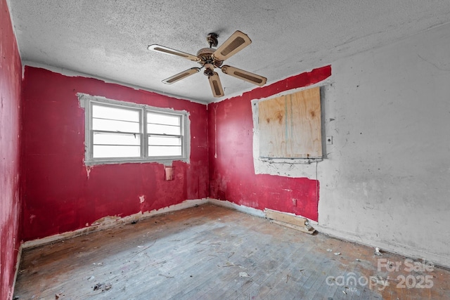 spare room featuring hardwood / wood-style flooring, ceiling fan, and a textured ceiling