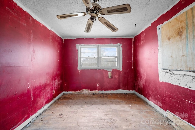 empty room with hardwood / wood-style flooring, a textured ceiling, and ceiling fan