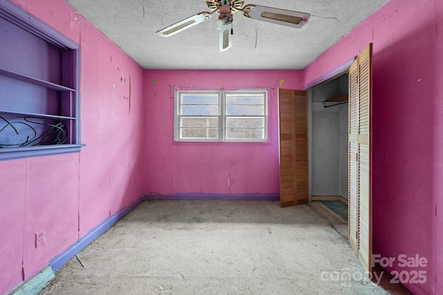 unfurnished bedroom with a closet, ceiling fan, light carpet, and a textured ceiling