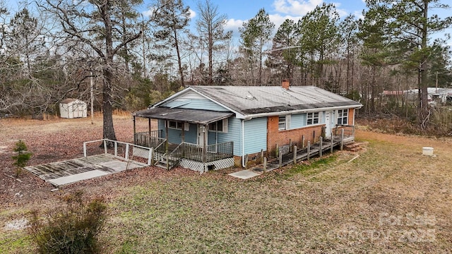 view of front of house featuring a front lawn and a storage unit