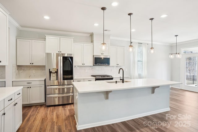 kitchen featuring hanging light fixtures, appliances with stainless steel finishes, and light countertops