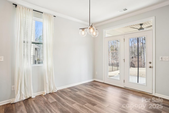 unfurnished dining area featuring baseboards, visible vents, wood finished floors, and ornamental molding