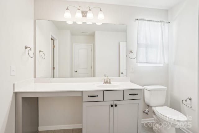 bathroom with visible vents, baseboards, vanity, and toilet