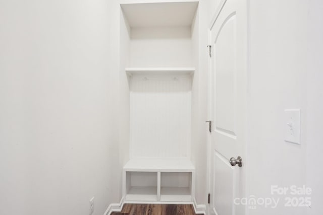 mudroom featuring dark wood-type flooring and baseboards