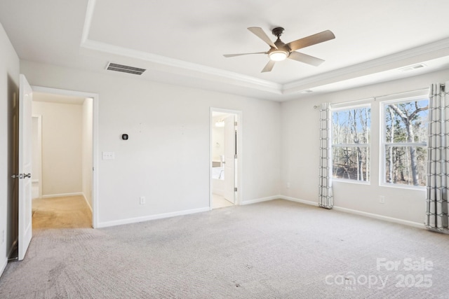 unfurnished bedroom featuring a tray ceiling, visible vents, and baseboards