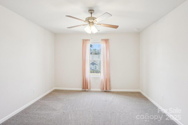 carpeted empty room featuring baseboards and a ceiling fan