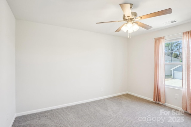 carpeted spare room with ceiling fan, visible vents, and baseboards