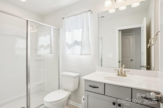 bathroom featuring toilet, a stall shower, and vanity