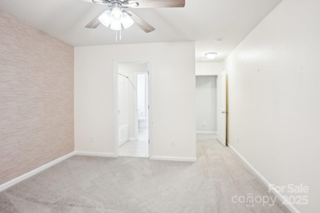 unfurnished room featuring light carpet, baseboards, and a ceiling fan