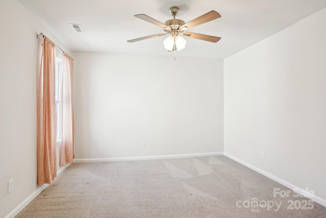 spare room featuring light carpet, baseboards, and a ceiling fan