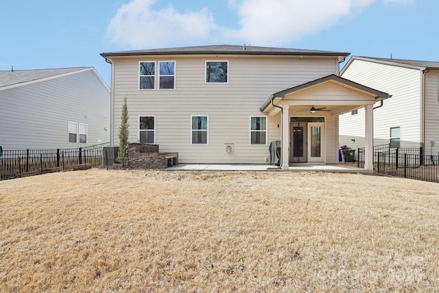 back of property with a ceiling fan, a patio area, a yard, and a fenced backyard