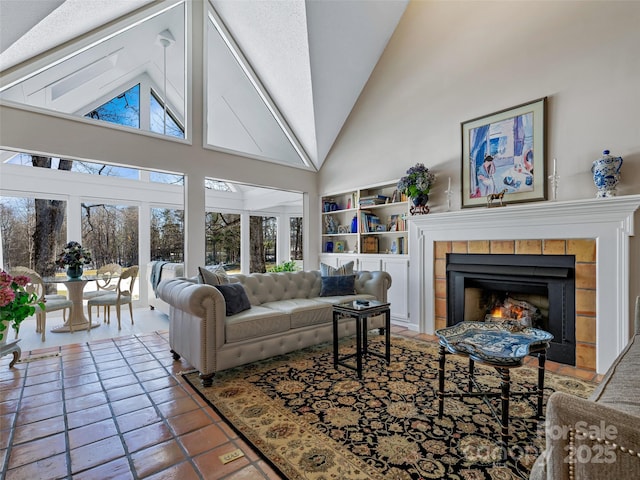 living room with a tile fireplace and high vaulted ceiling