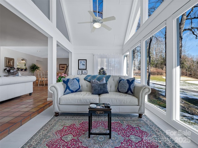 sunroom / solarium with vaulted ceiling, a healthy amount of sunlight, and ceiling fan