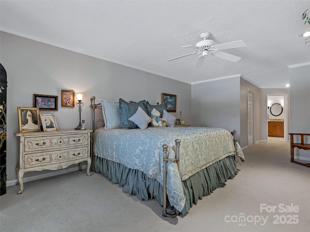 carpeted bedroom featuring ornamental molding, a textured ceiling, ceiling fan, and ensuite bath