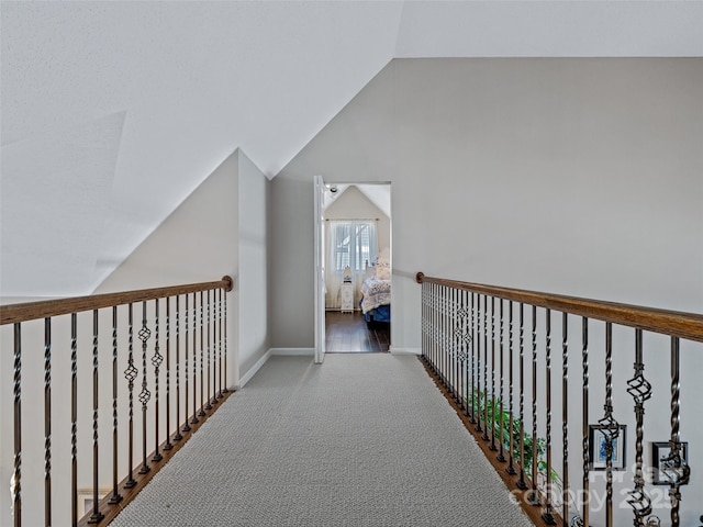 hall featuring vaulted ceiling and carpet