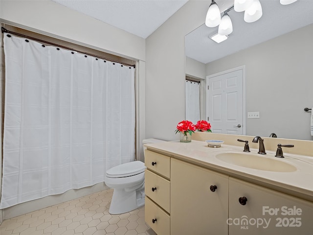 bathroom with tile patterned flooring, vanity, a textured ceiling, and toilet