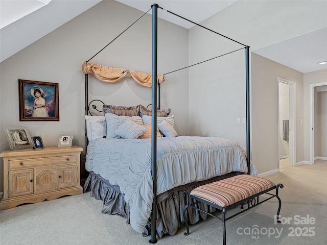 bedroom featuring light colored carpet, lofted ceiling, and connected bathroom