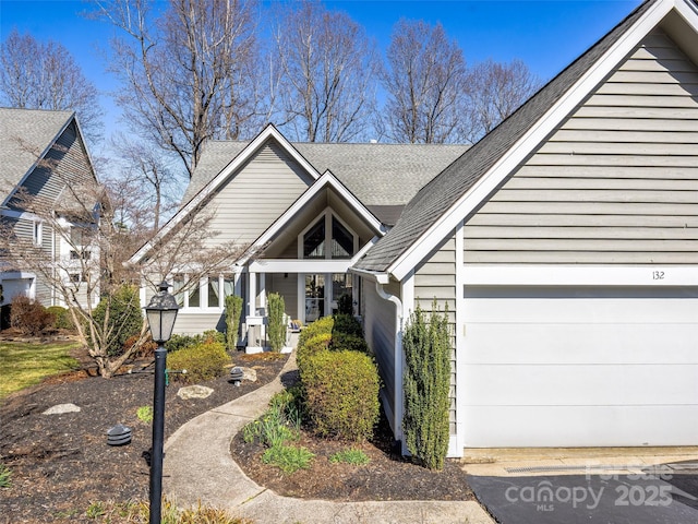 view of front of house featuring a shingled roof and a garage
